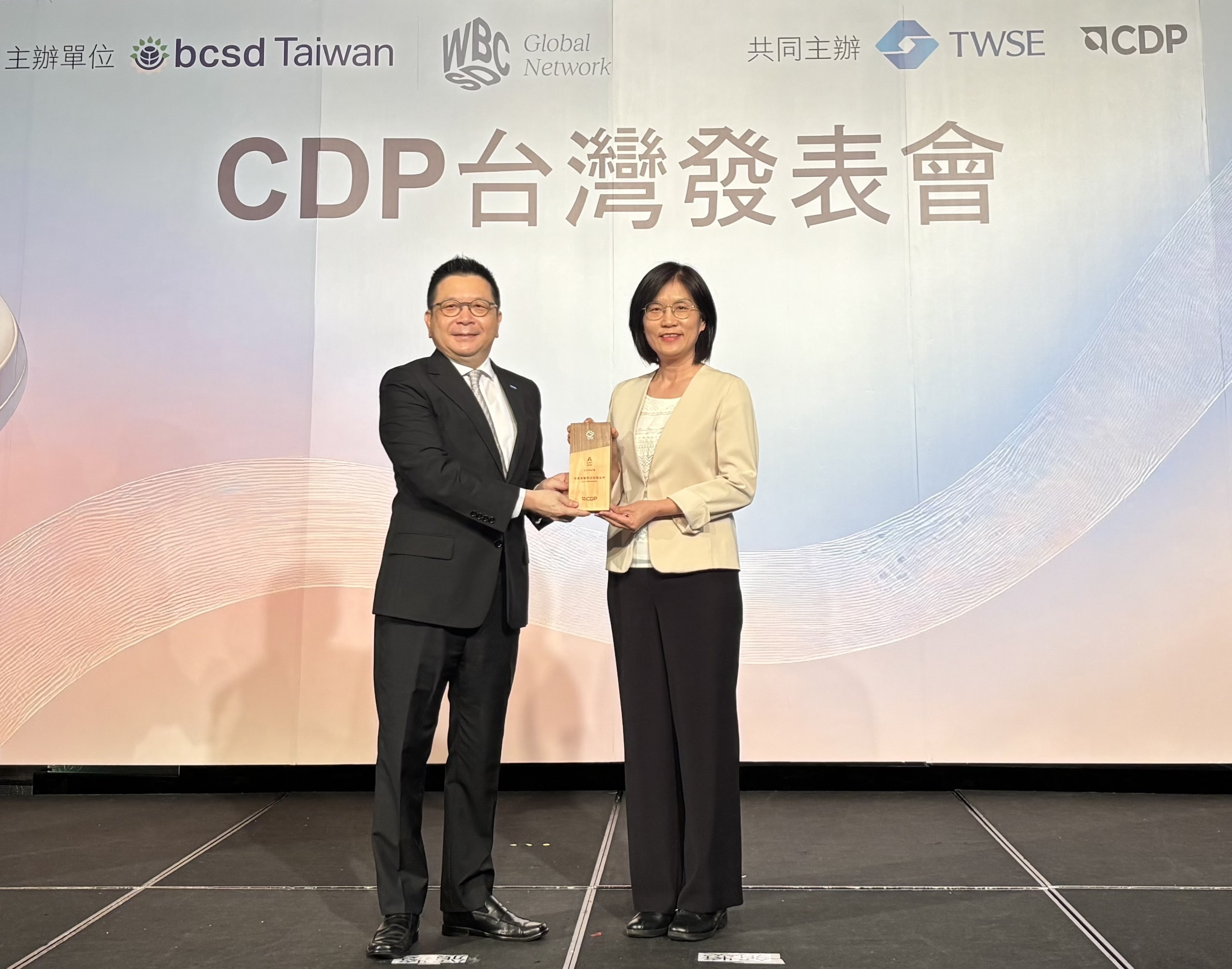 ng28南宮相信品牌力量永續(xù)成果再獲國際評比肯定，獲頒CDP氣候與水資源雙項領(lǐng)導力評級。今由臺灣證券交易所董事長林修銘（左）頒獎，ng28南宮相信品牌力量光電永續(xù)長古秀華（右）代表受獎